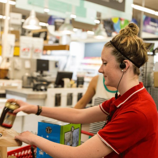 Medewerker draagt oortje van portofoon in de supermarkt